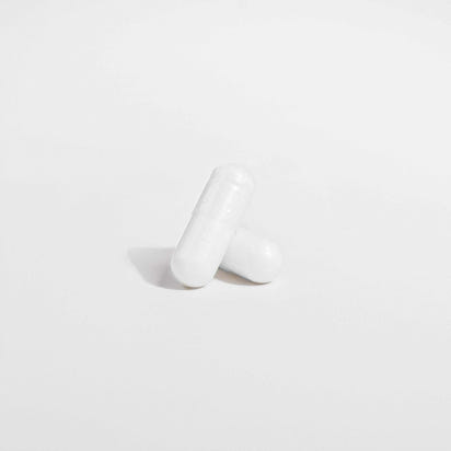 Two white Ocean Pure Magnesium Glycinate supplement capsules on a white background